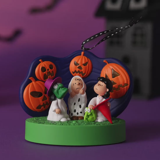 The Peanuts® Gang 60th Anniversary Spooked Trick-or-Treaters With Light and Sound — 2026 Hallmark Keepsake Halloween Ornament featuring Linus and friends with jack-o'-lanterns in a festive setting.