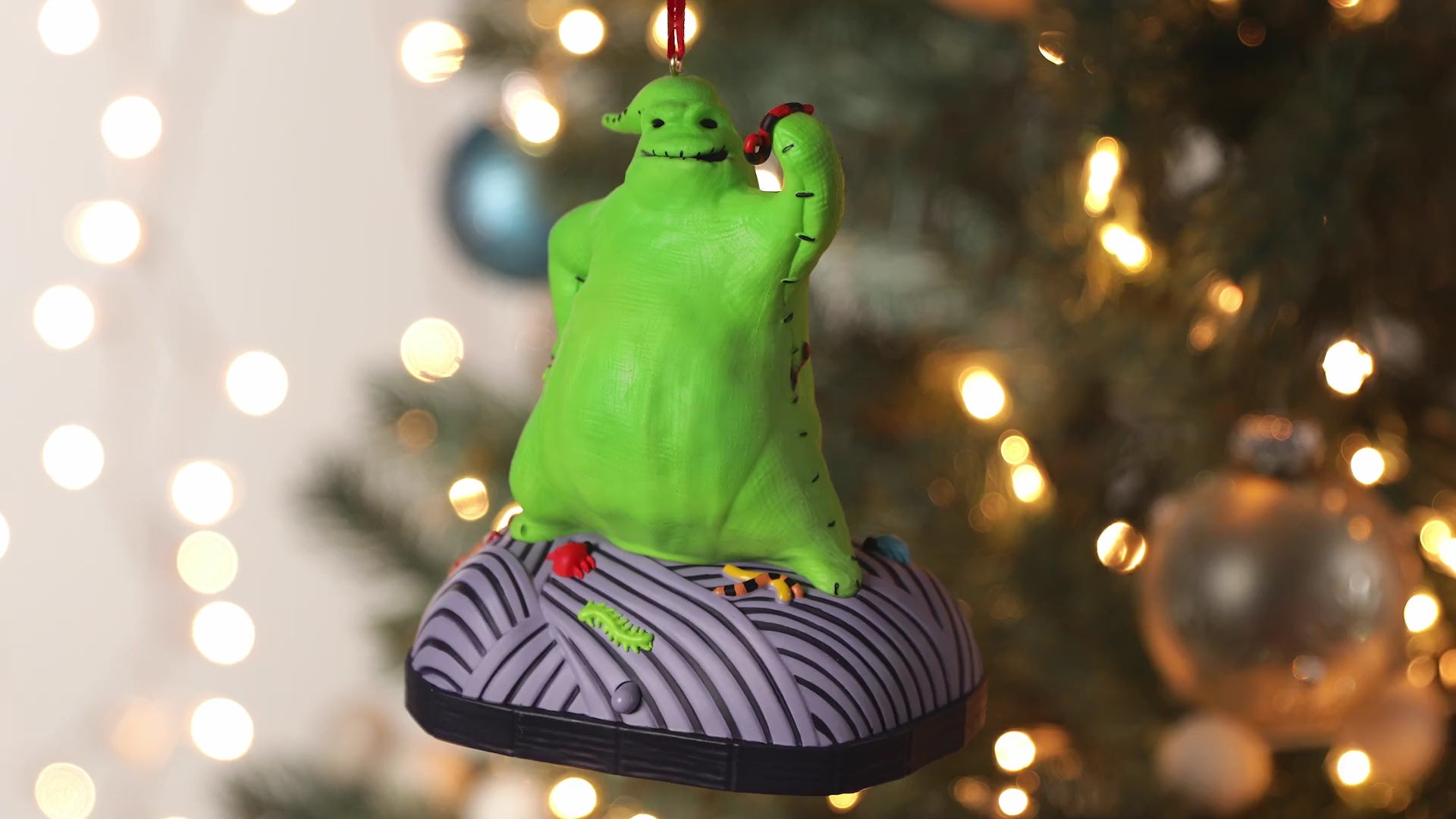 Disney Tim Burton's The Nightmare Before Christmas, Oogie Boogie With Sound and Motion — Hallmark Keepsake Christmas Ornament, close up with festive bokeh.