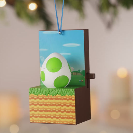 Nintendo Super Mario™ It's Yoshi! With Sound and Motion — 2026 Hallmark Keepsake Christmas Ornament, close up of Yoshi's egg design with green spots and a festive background.