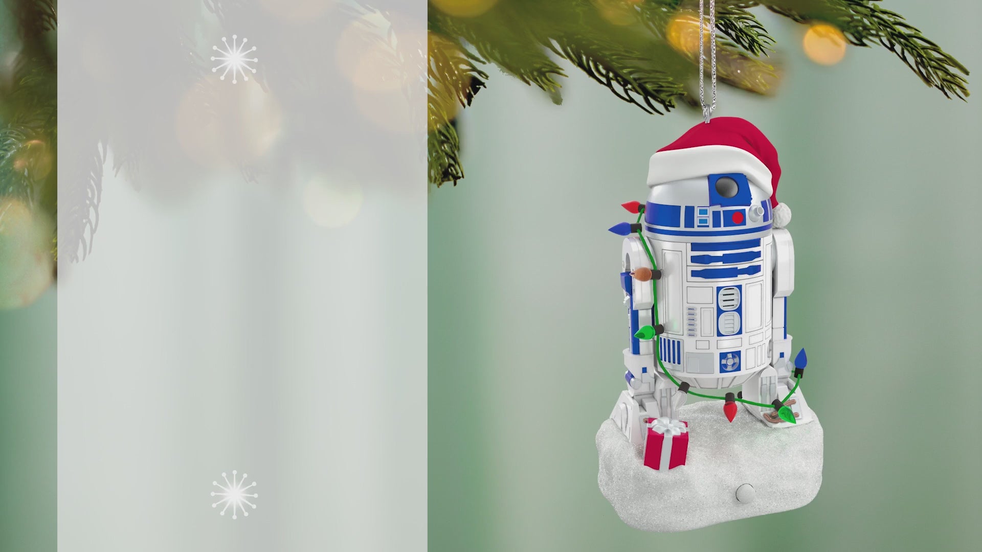 Star Wars™ Decked-Out Droid Musical — 2026 Hallmark Keepsake Christmas Ornament hanging from a tree branch, featuring R2-D2 in a Santa hat and lights.