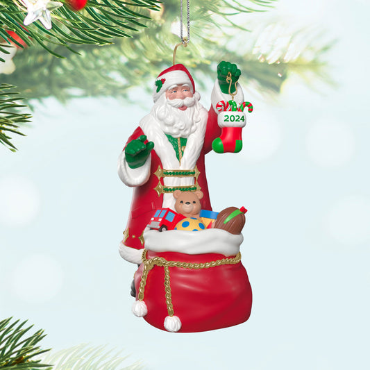 The Perfect Gift — Hallmark Keepsake Christmas Ornament, Santa holding a 2024 stocking, with toys in a red bag, close up view.
