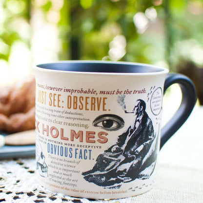 Unemployed Philosophers Guild - Sherlock Holmes Mug featuring detailed quotes and images, viewed from a side angle, with cookies in background.