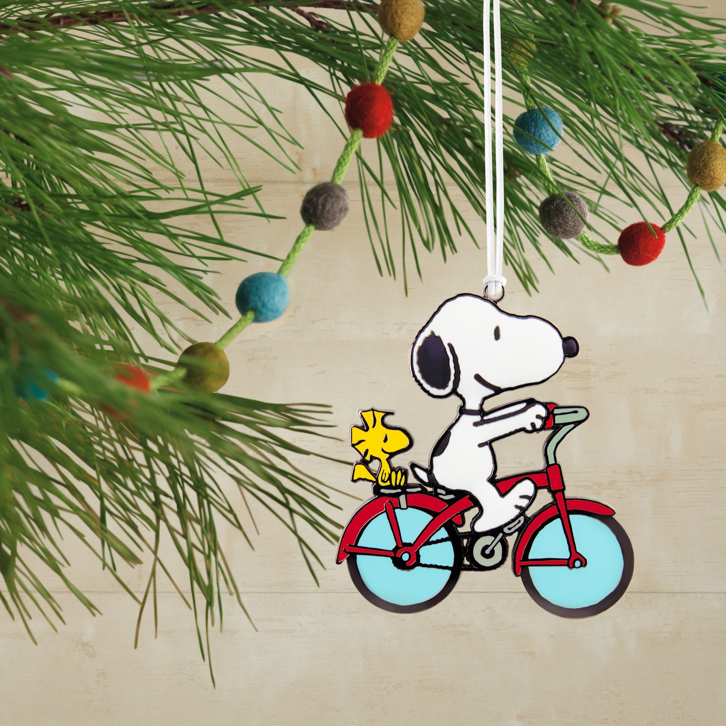 Peanuts® Snoopy and Woodstock on Bicycle With Dimension — Hallmark Christmas Ornament hanging from festive greenery, colourful beads detail.