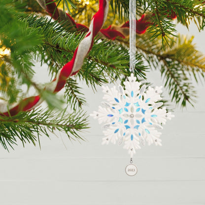 Snowflake (Porcelain) — 2023 Hallmark Keepsake Christmas Ornament hanging delicately from a Christmas tree, showcasing intricate detail and blue accents.