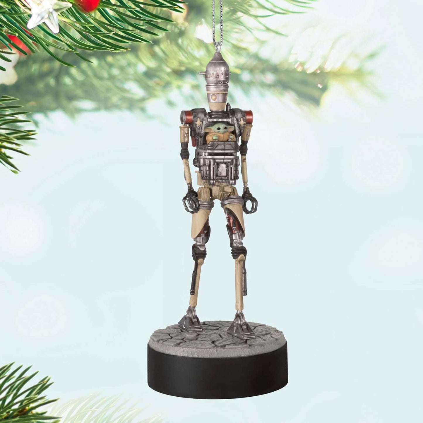 Star Wars™: The Mandalorian™ Grogu™ Operating IG-12™ Ornament With Sound — 2025 Hallmark Keepsake Christmas Ornament, close up, hanging design against Christmas tree branches.