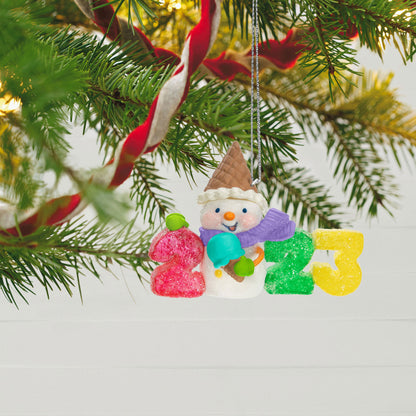 Sweet Decade — Hallmark Keepsake Christmas Ornament, plastic decoration, featuring a snowman with ice cream cone and gumdrop numbers 2023, hanging on a Christmas tree.