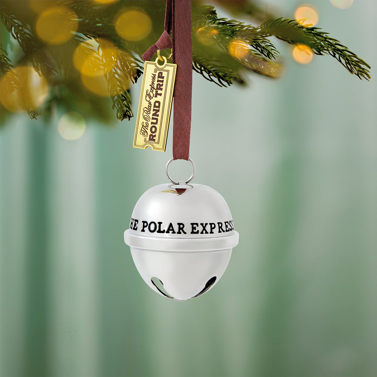 The Polar Express™, Santa's Sleigh Bell 2026, metal ornament, shiny finish, hanging on a Christmas tree.