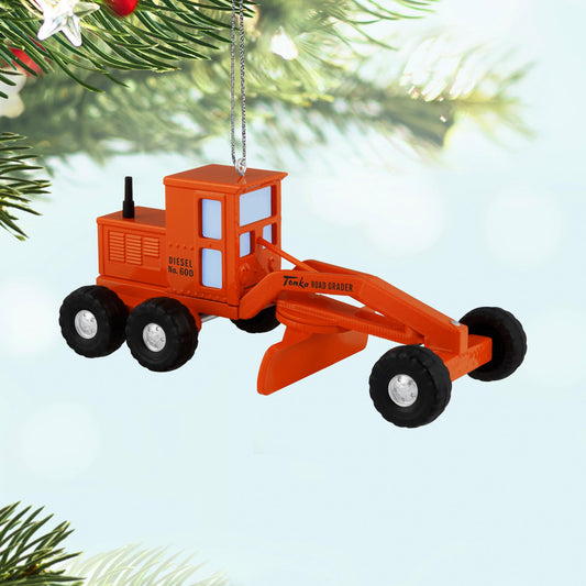 Hasbro® Tonka®, Road Grader — 2025 Hallmark Keepsake Christmas Ornament, vintage orange die-cast design, hanging on a tree branch.