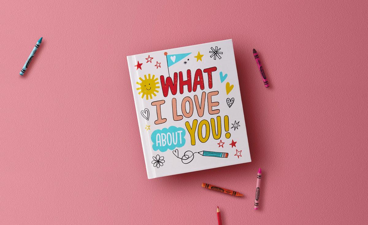 What I Love About You! A Color-Your-Own Recordable Storybook with colourful hand-drawn cover on a pink background, surrounded by crayons.