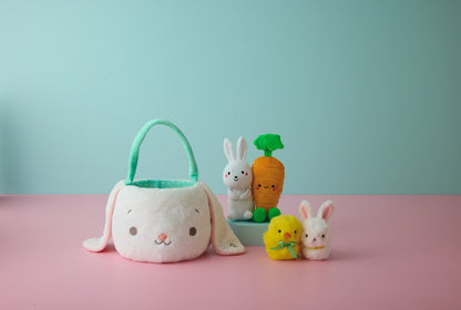 Hallmark Zip-a-Long Bunny Stuffed Animal in cute Easter scene with plush bunny basket, carrots, and baby animals on pink background.