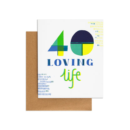 Loving Life Neon 40th Birthday Card featuring bright colours and geometric designs with kraft envelope in flat lay view