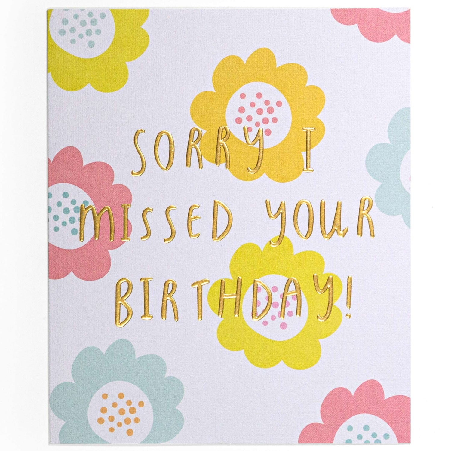 Sorry I missed your birthday pastel flowers card featuring colourful flower illustrations and gold foil lettering, flat lay view.