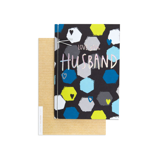 Love You Husband Colourful Appreciation Card with hexagon patterns and a striped kraft envelope in a flat lay view.