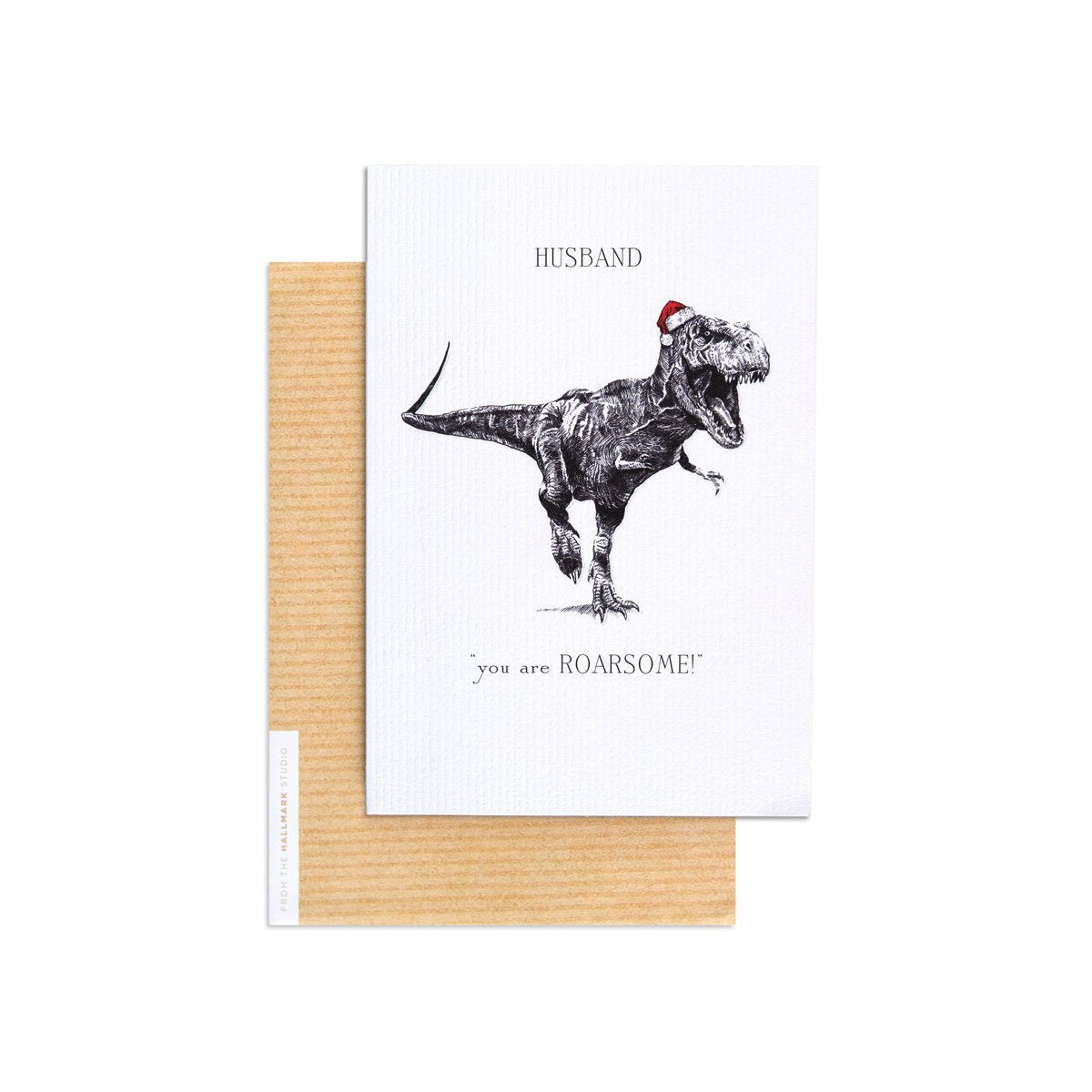 Christmas card for husband - festive T-Rex design with Santa hat, featuring embossed text and kraft envelope on a flat lay.
