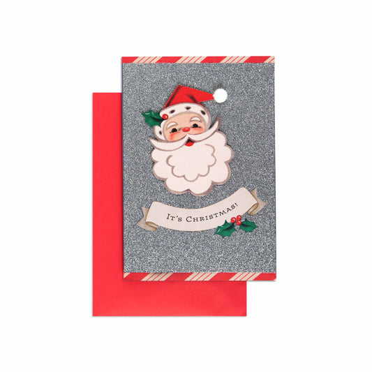 Christmas card - silver glitter Santa with a cheerful illustration, red envelope, and festive holly accents.