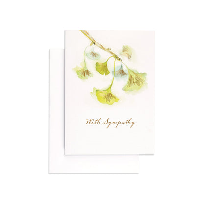Kind & Compassionate Green Cherry Blossom Sympathy Card featuring an illustration of green blossoms and the message 'With Sympathy', flat lay view.