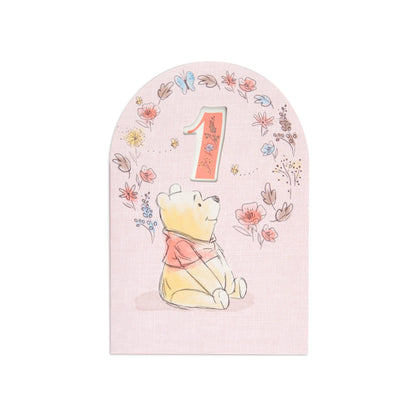 Lovely Disney Winnie The Pooh Sweet As Honey 1st Birthday Card featuring Pooh beside a cut-out '1' and floral designs in pastel colours.