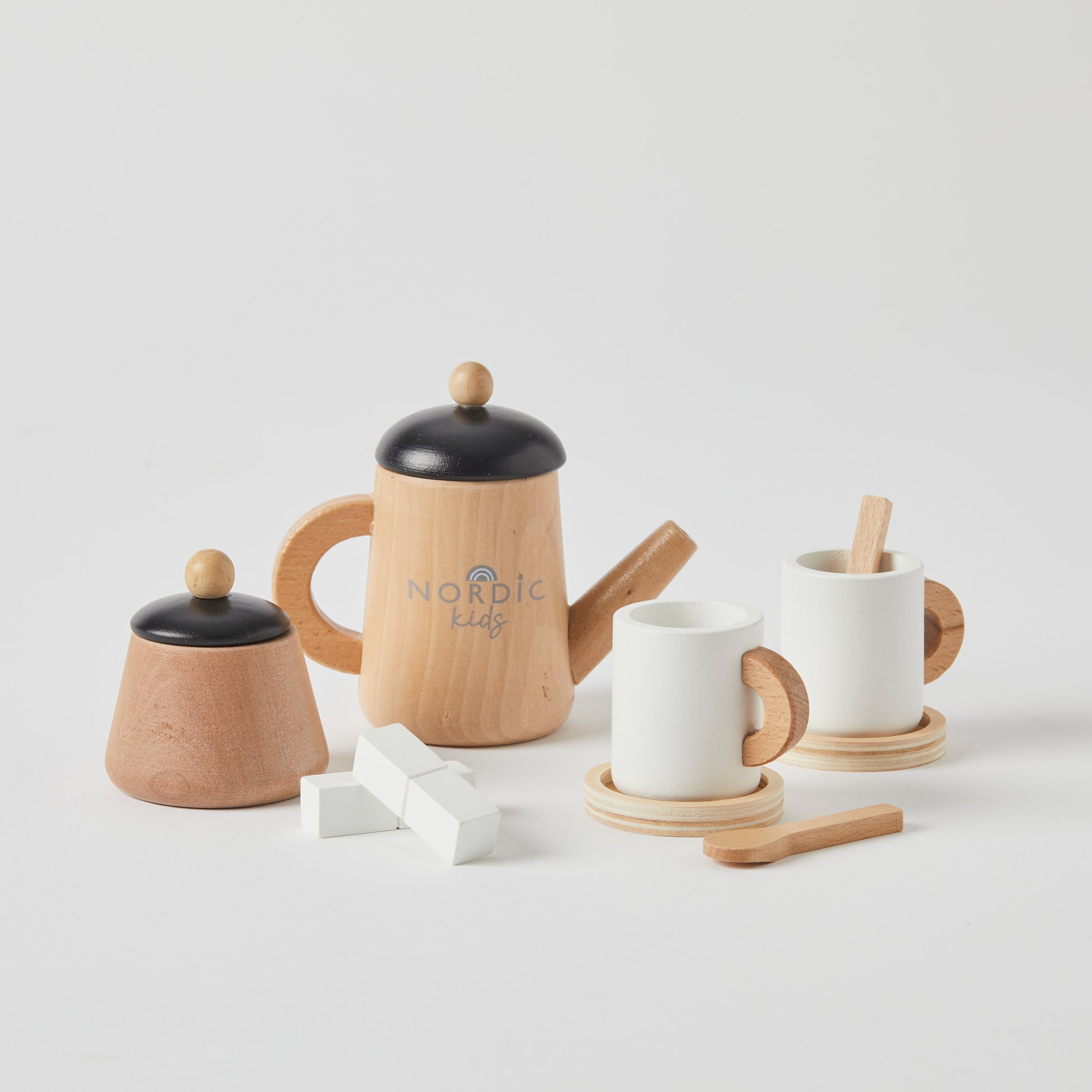 Wooden tea set in natural wood with black and white accents, including a teapot, cups, and accessories on a light background.