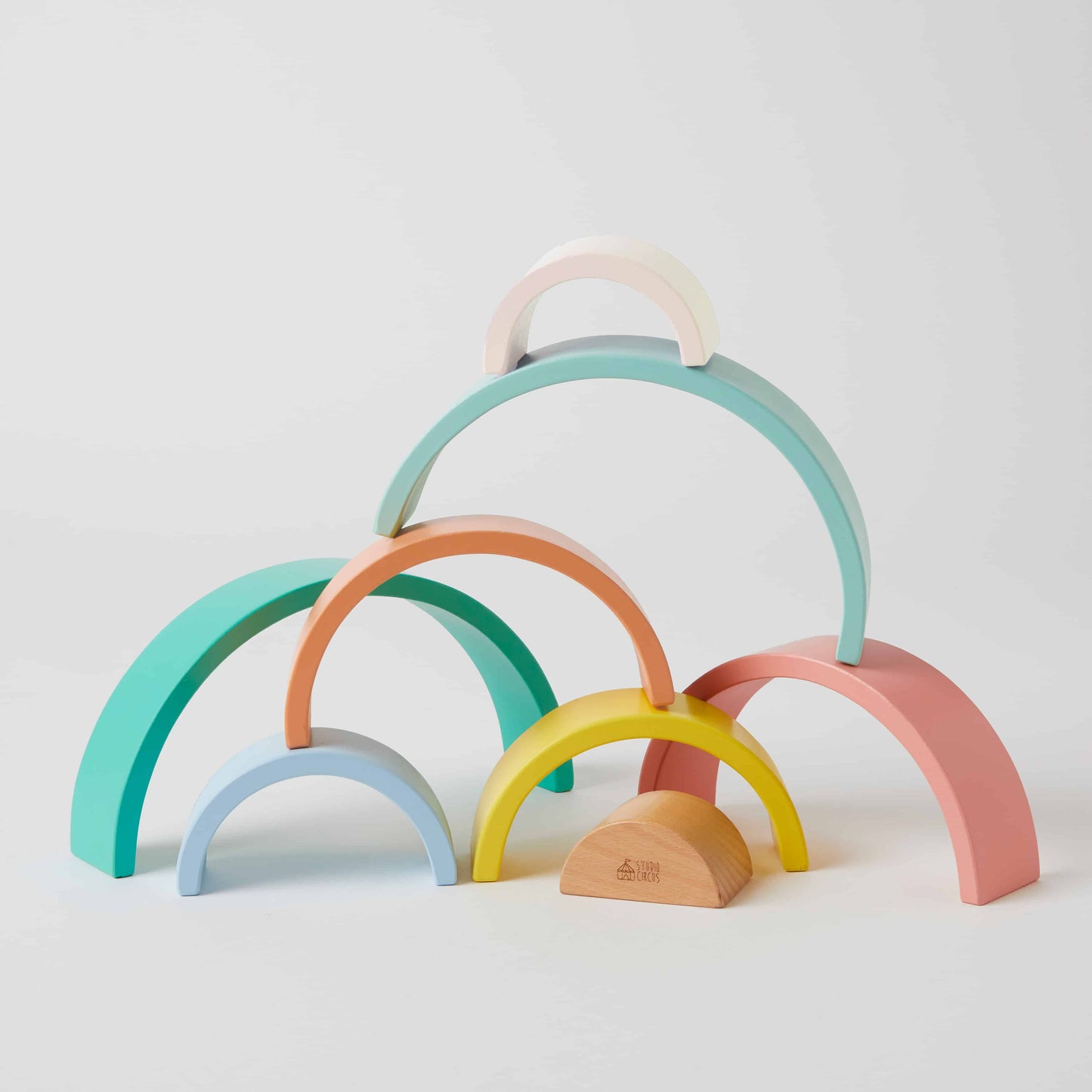 Rainbow Stacker in pastel colours made from wood, featuring semi-circular shapes in a creative display on a neutral background.